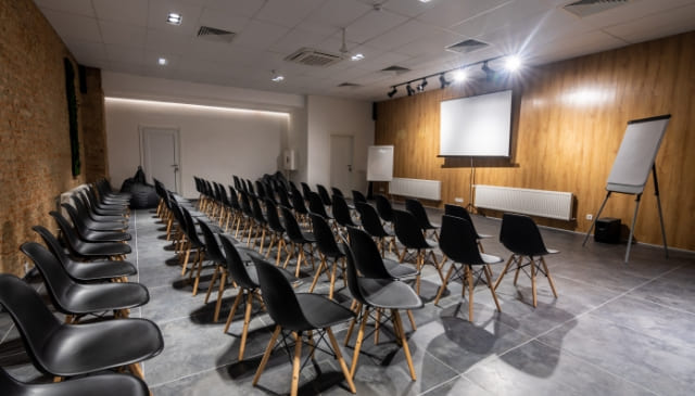 椅子が並びスクリーンがある会議室